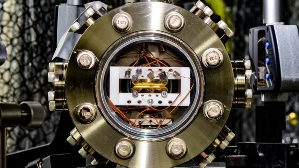 Close up view of a Quantum Processor with many cables and filaments all feeding into a central testing unit