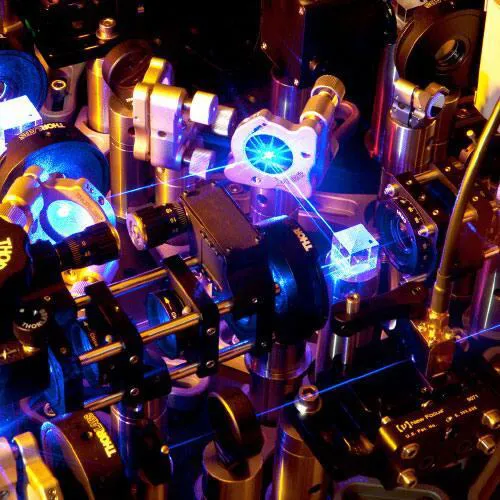 Blue tinted lasers bouncing off mirrors, through lenses and prisms